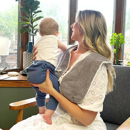 Woman wraring burp cloth while shifting baby from one shoulder to the other